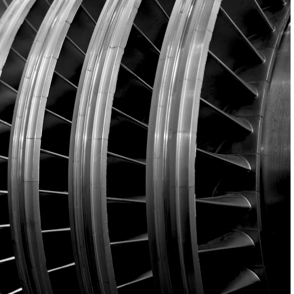 Close-up view of aeroderivative turbine blades showcasing intricate design and engineering. The image highlights the layered structure and aerodynamic features essential for efficient gas compression and energy generation.