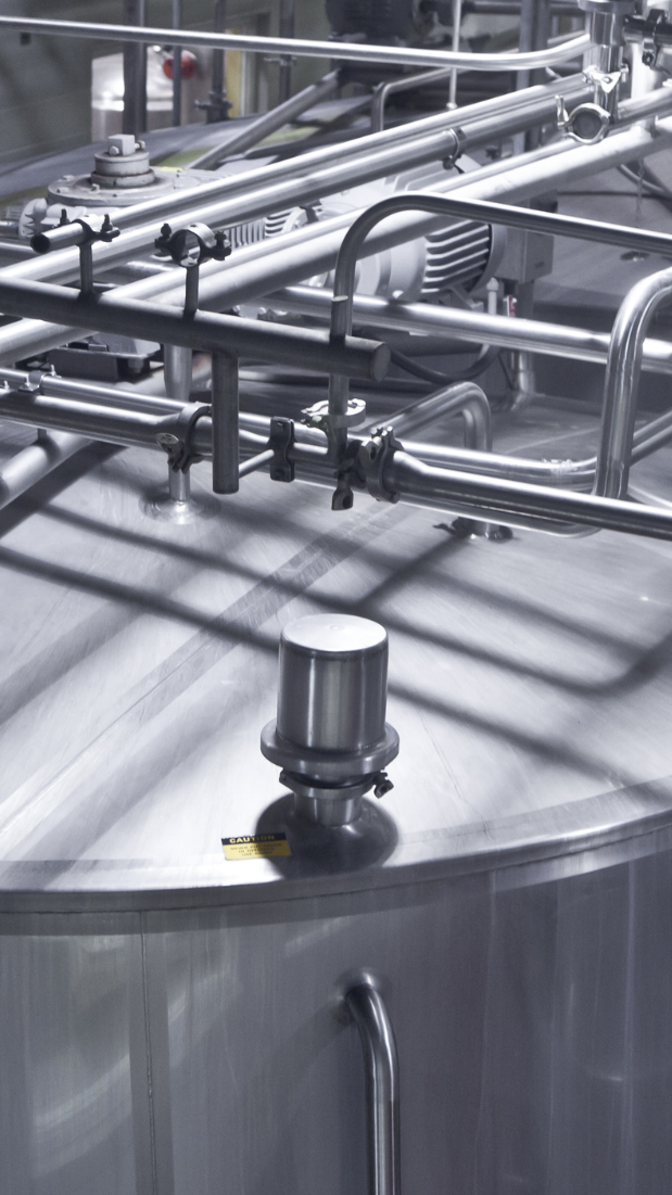 Industrial chemical processing equipment featuring stainless steel tanks and piping systems, utilized in petrochemical manufacturing.