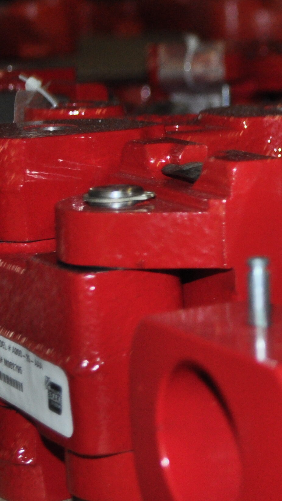 Close-up of red steel components stacked on a warehouse shelf, showcasing the precision manufacturing processes in the steel industry.