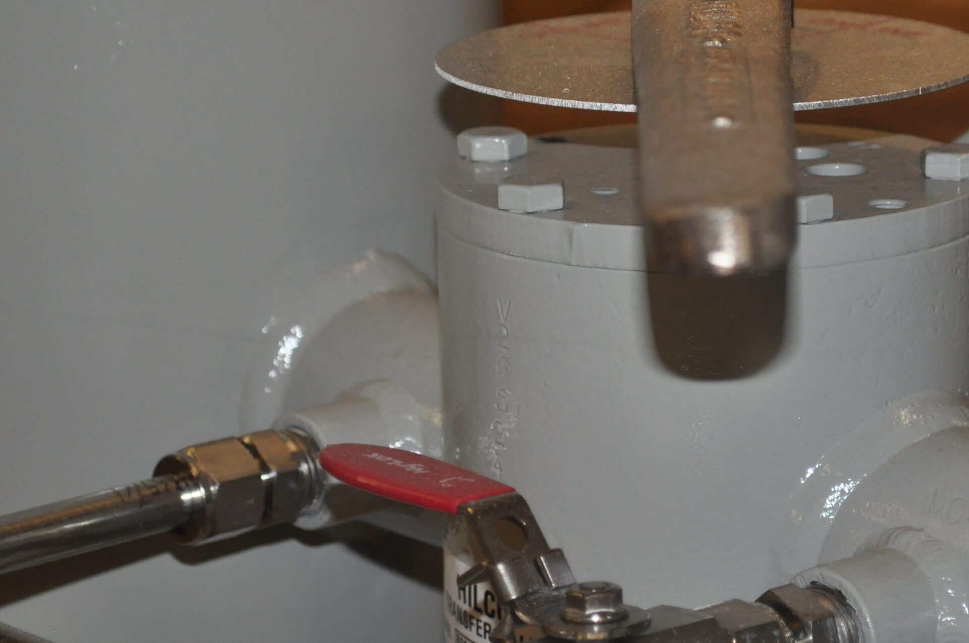 Close-up of a valve assembly used in skid packaging, featuring a metallic handle and connected piping, showcasing industrial equipment designed for efficient fluid management.