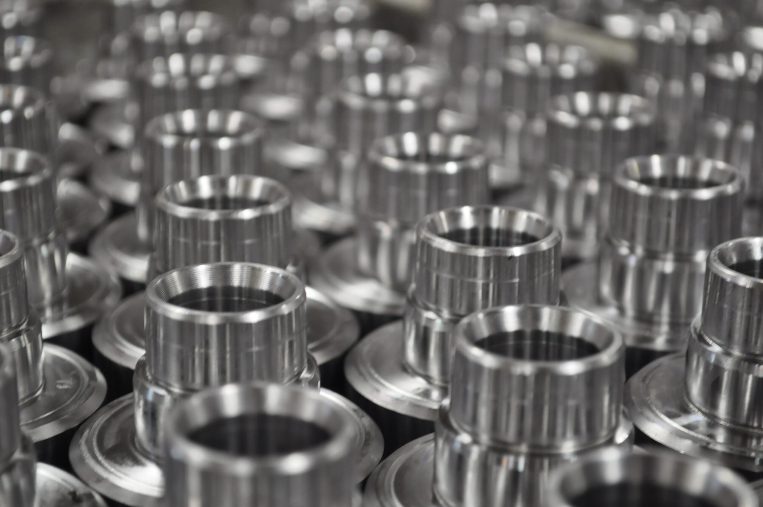 Close-up of metallic components used in outdoor power equipment, showcasing precision-engineered parts arranged in a manufacturing setting.