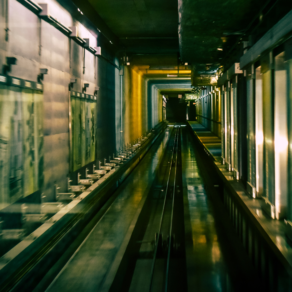 Interior view of an elevator shaft showing the tracks and braking systems, highlighting the structure and mechanics essential for elevator operation and safety.
