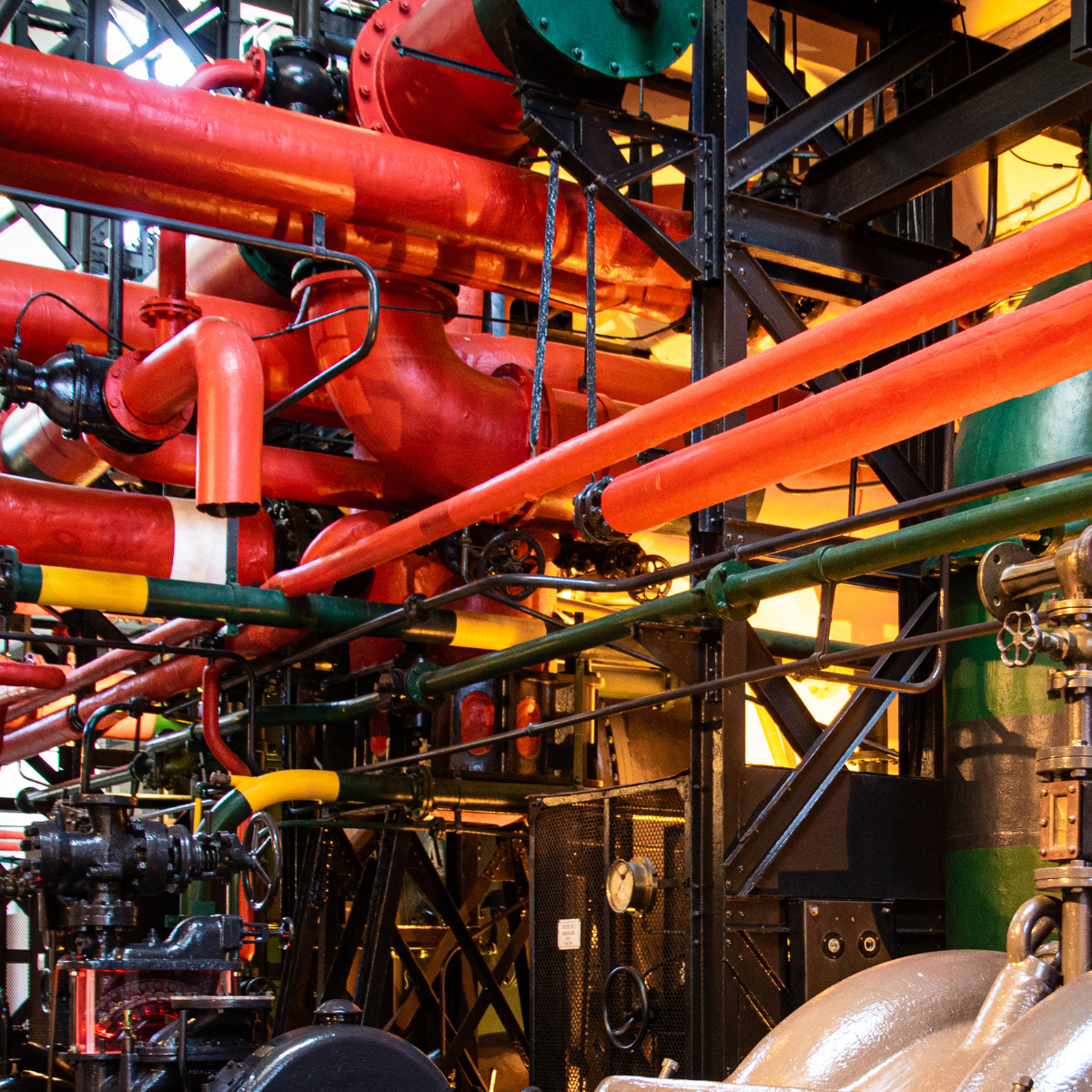 Industrial engine starter system featuring a complex arrangement of colorful pipes, valves, and machinery, illustrating the intricate components essential for engine operation and maintenance.