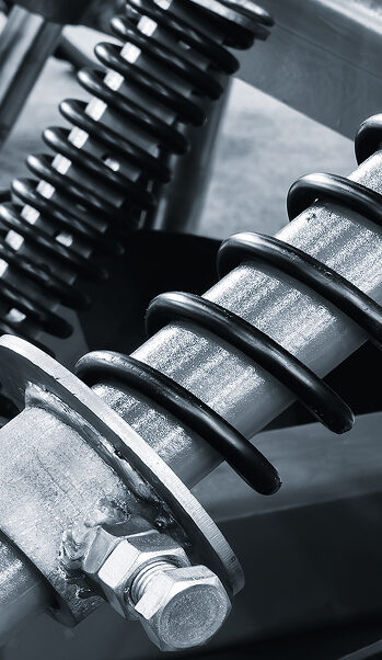Close-up of heavy machinery components showcasing metal springs, hydraulic systems, and structural elements, highlighting the engineering and design of modern industrial equipment.